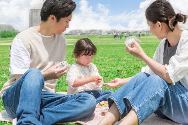 秋ピクニックでお弁当を食べる親子の写真