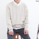 免許証の写真にグレーの服装で撮影する人
